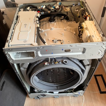 LG front-load washer with top panel removed, showing internal wiring and control board — Ottawa repair